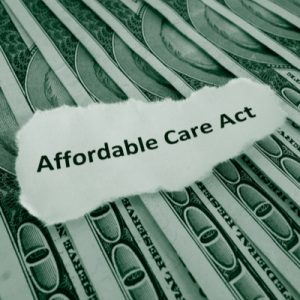 Money with the words "Affordable Care Act" on top.