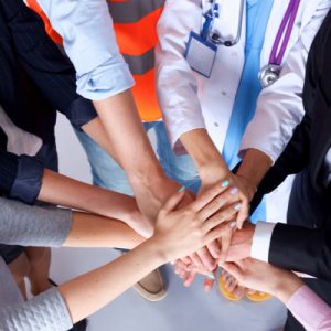 Medical health professionals with their hands together.