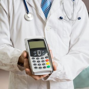 A doctor holding a credit card reader.