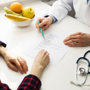 A doctor and patient go over a sheet of paper together.