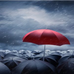 A red umbrella opened above many open black umbrellas, symbolizing new health insurance coverage.