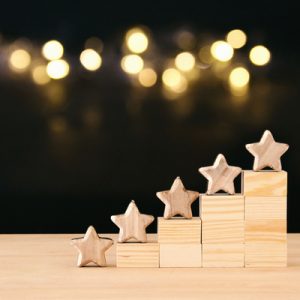 Five wooden stars arranged on wooden blocks.