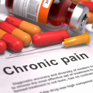 Pill bottle and red and orange pills over a sheet reading "Chronic pain".