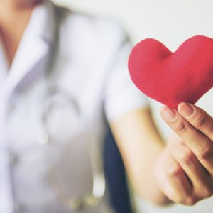 A Michigan healthcare worker holding a paper heart.