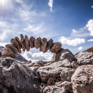 A balanced archway of stones, indicating trust in public health.