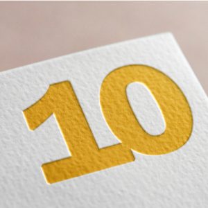 A scorecard with a yellow 10 on it, the age of the ACA