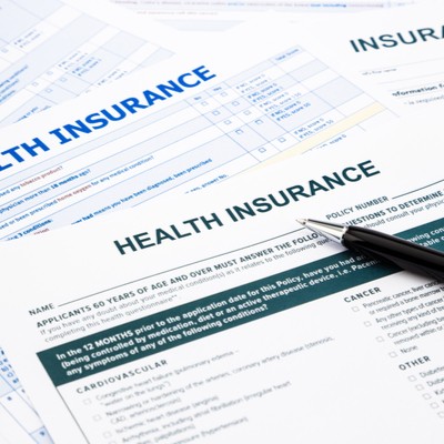 Health Insurance paperwork with a pen