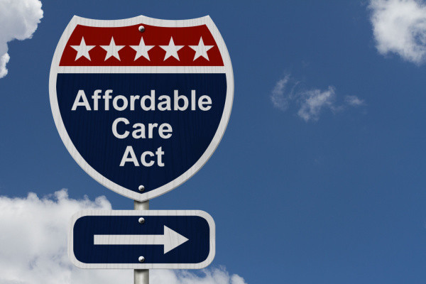 Road sign reading Affordable Care Act, and featuring an arrow