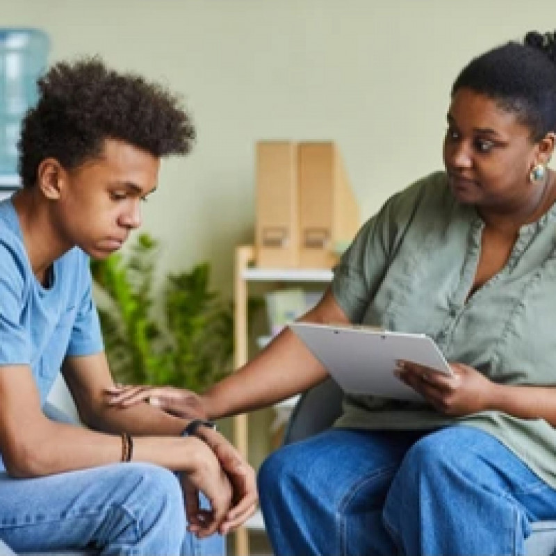 A behavioral health worker offers support to a teenager