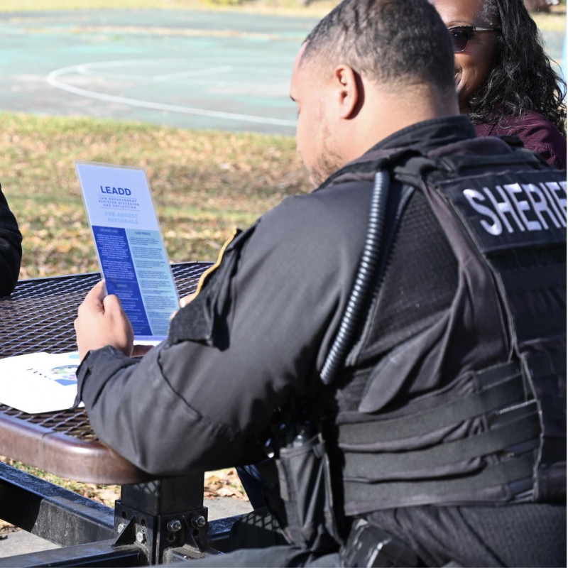 Sherriff's Officer reading pamphlet on diversion and deflection