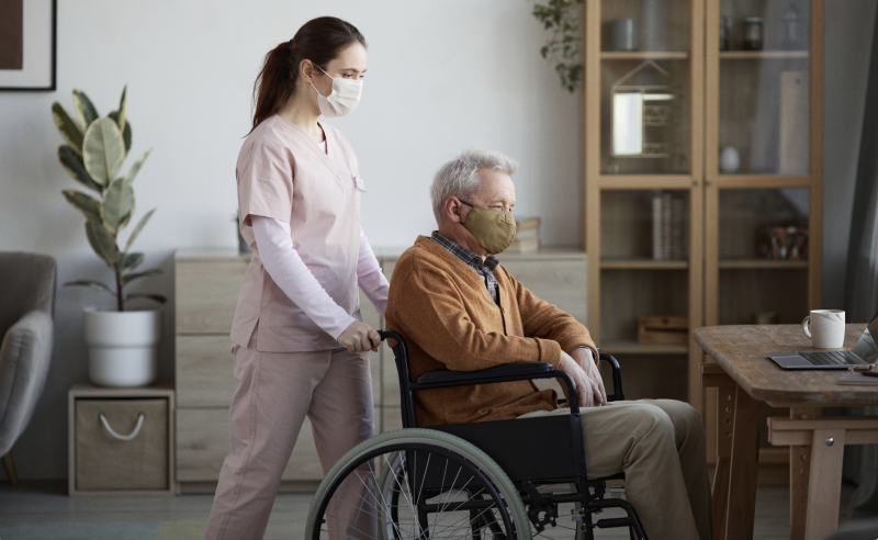 Caregiver pushing man in wheelchair
