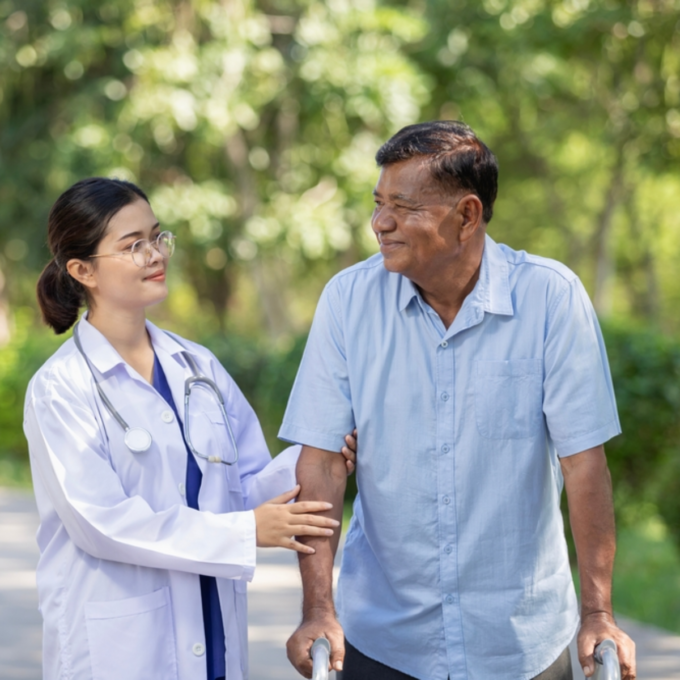 Doctor helps elderly man walk with a walker