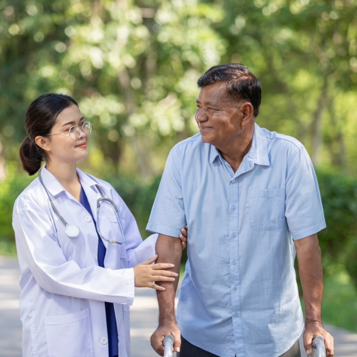 Doctor helps elderly man walk with a walker