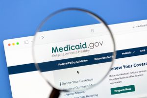 A magnifying glass hovers over the URL Medicaid.gov