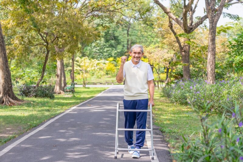 Senior man walking with a walker outside