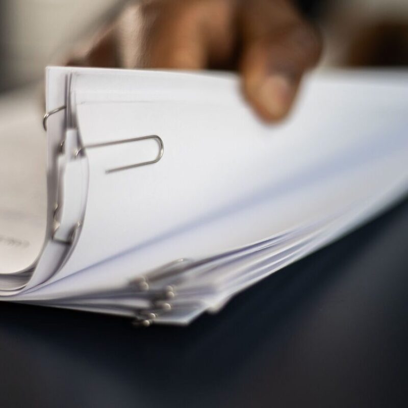 Man flips through a stack of paperwork.